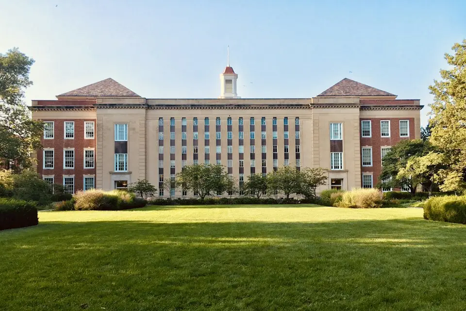 A historic university building across a green campus lawn